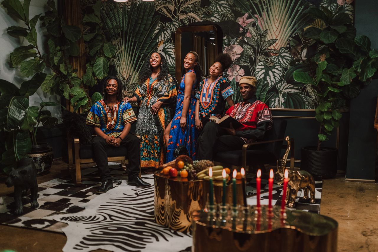 The Art of Drawing Readers In: Your attractive post title goes here Group celebrating Kwanzaa with traditional clothes and candles indoors.